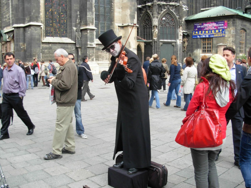 Człowiek grający na skrzypcach po wrzuceniu monety
